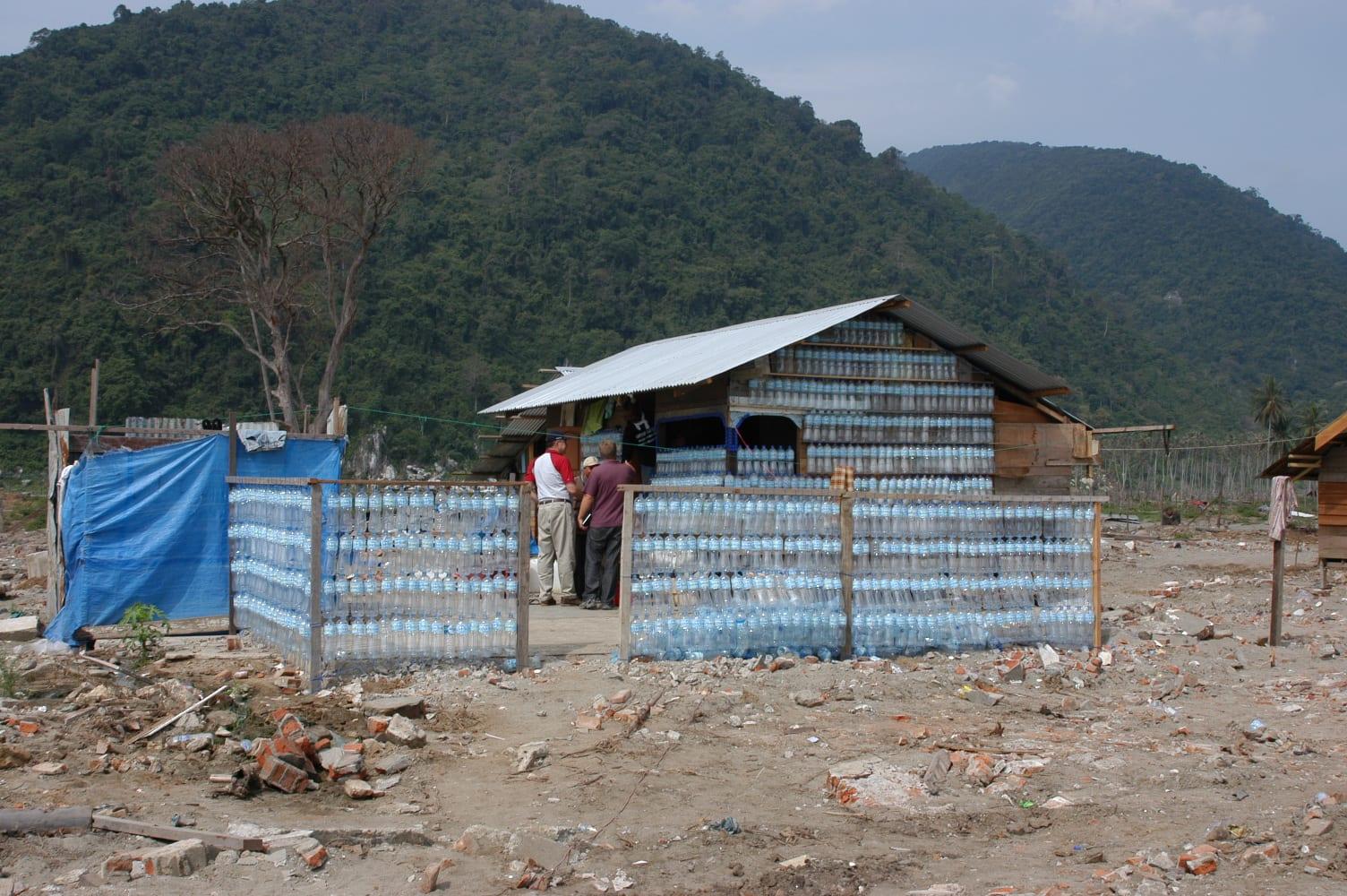 A temporary house and fence built from walls of stacked plastic bottles after the tsunami